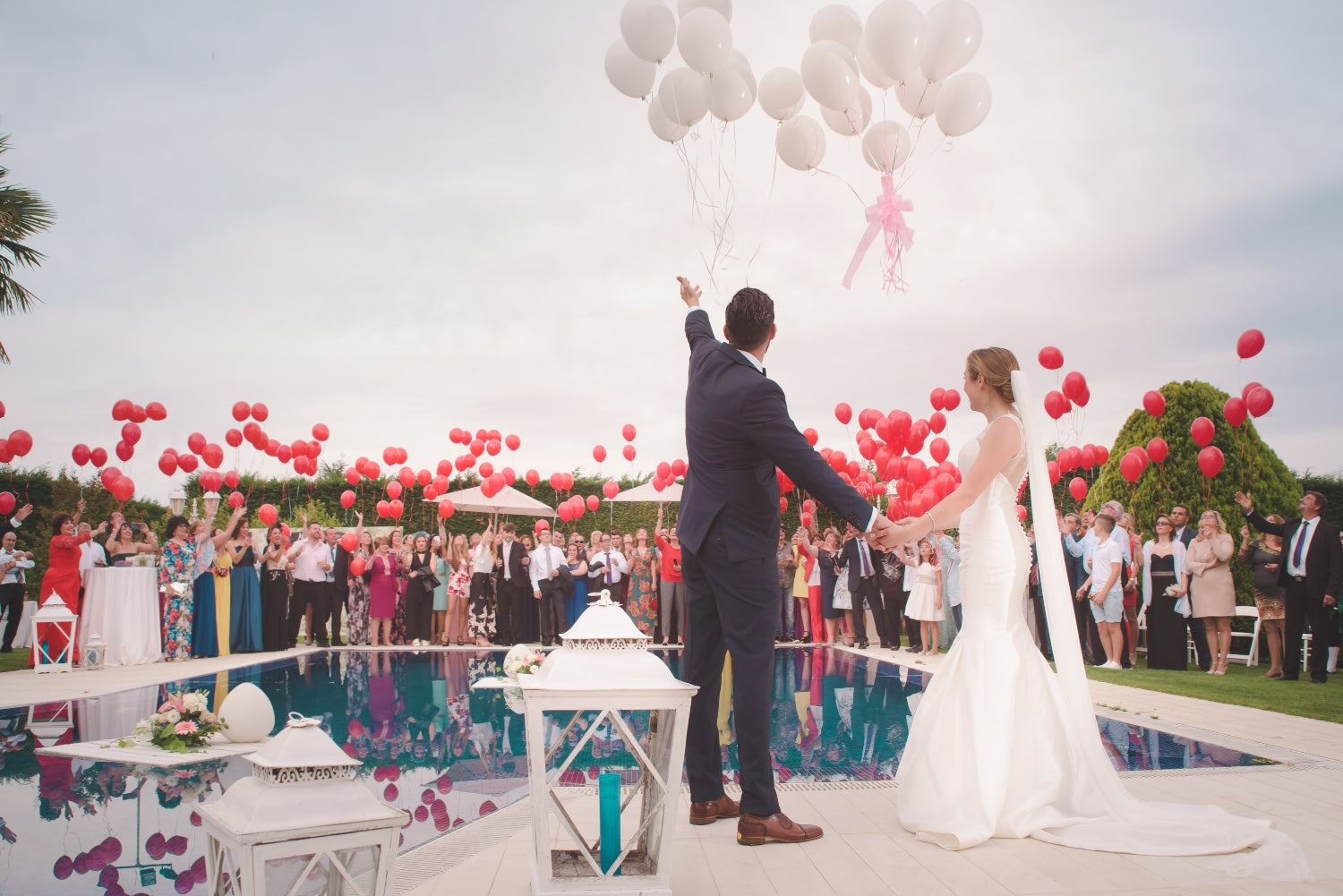 wedding at the pool with decoration of red and white balloons
