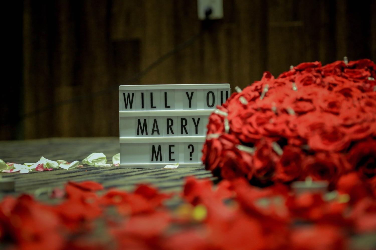 a bouquet of red roses with an inscription in the background