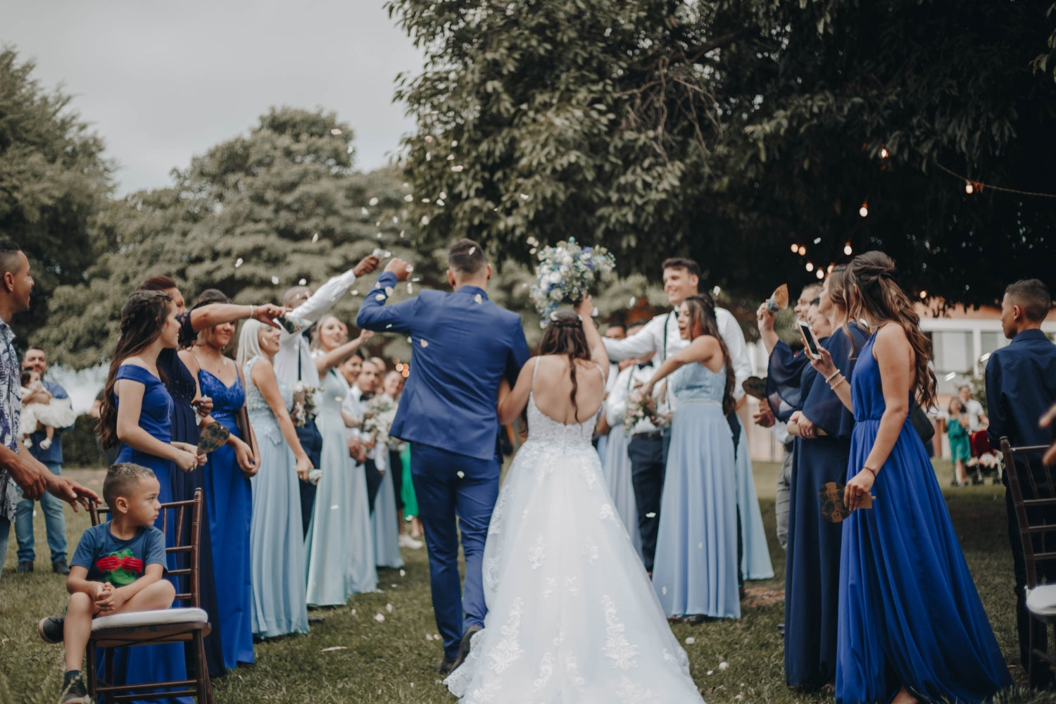 a couple with guests at an outdoor wedding